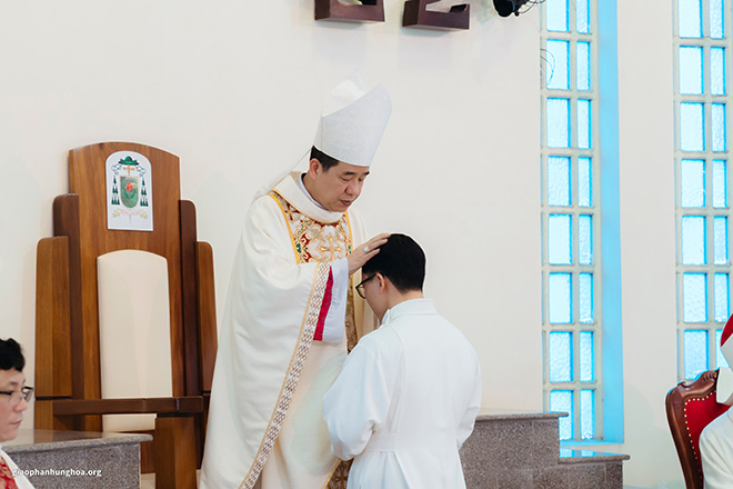 Đức Giám mục đặt tay trên đầu các tiến chức nói lên việc thông ban Thánh Thần