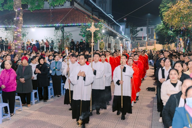 đoàn rước trang trọng từ nhà thờ tiến ra đền thánh trong tiếng hát vang lừng ca ngợi các Thánh Tử Đạo anh hùng