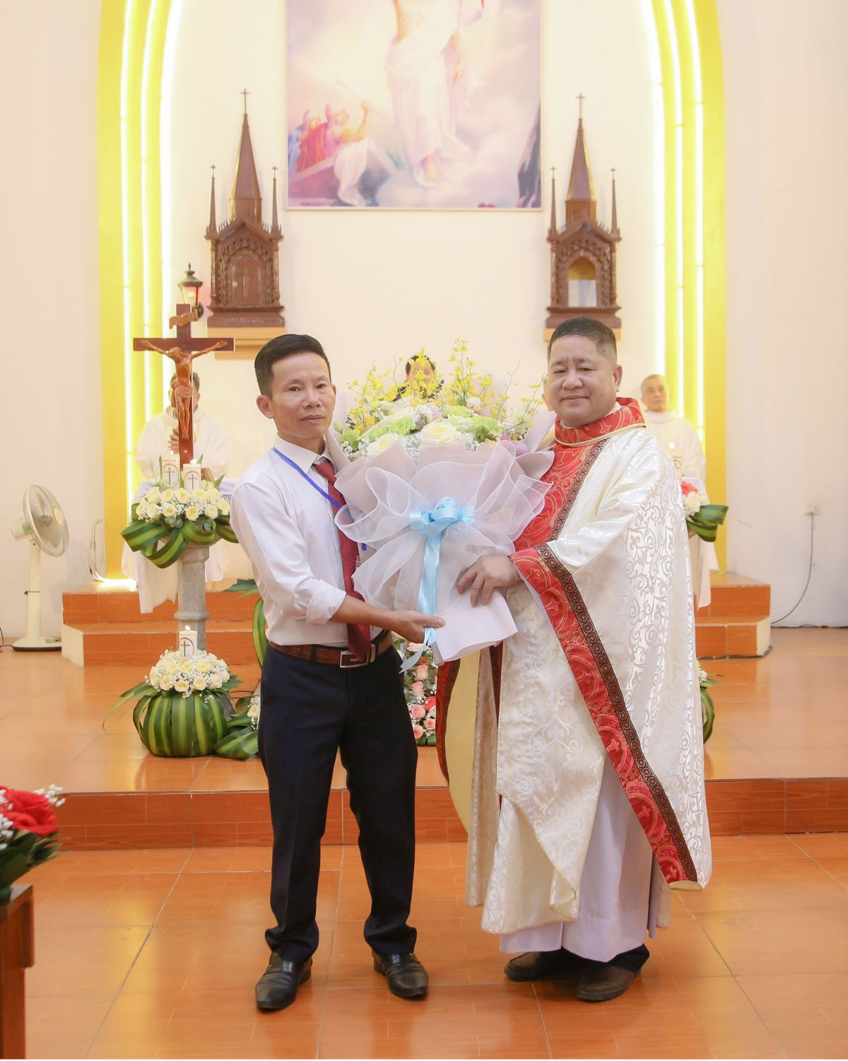 Đại diện cộng đoàn Giáo xứ Vân Đồn tặng hoa chào mừng Cha tân chính xứ Giuse