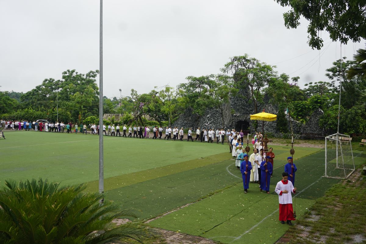 Cộng đoàn tín hữu theo sau Thánh giá, tiến vào Nhà thờ